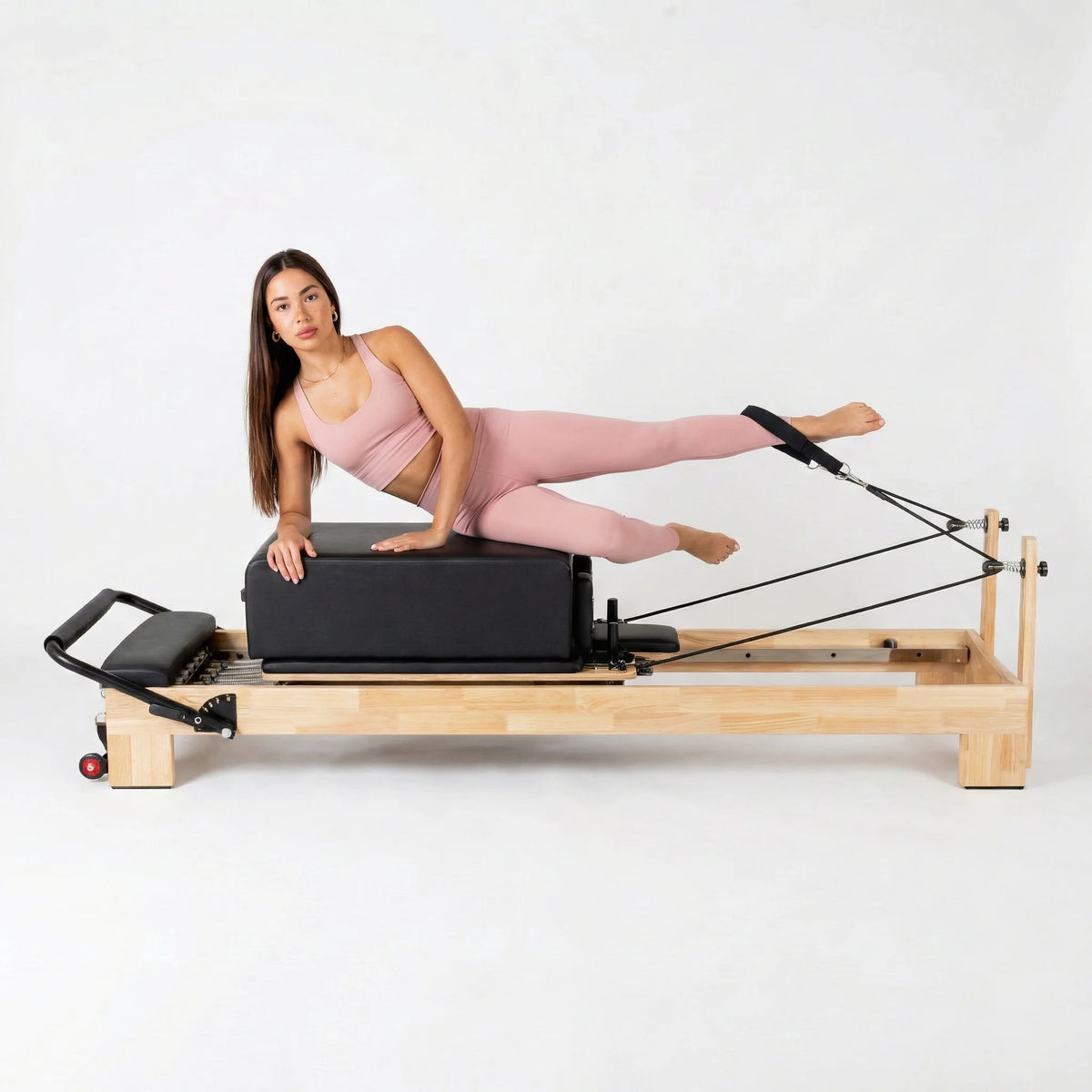 Box reformer sur Pilates Reformer, coloris noir, avec utilisatrice